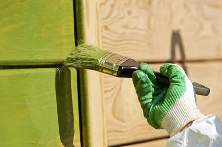 Painter applying exterior paint during mild spring day in Richmond, VA